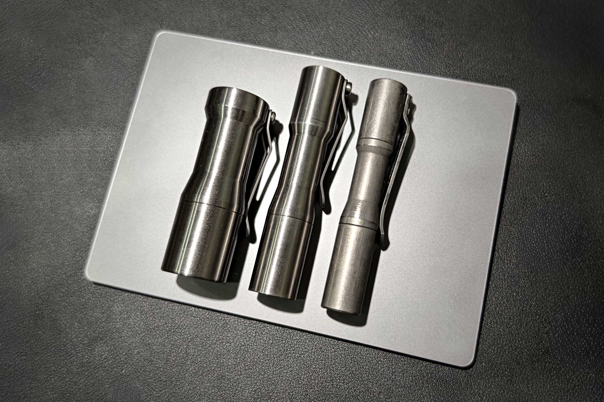 Đây là 3 chiếc đèn pin CWF mà mình có, từ trái sang phải: Peanut raw titanium/Mini raw titanium/Mini click tumbled titanium, đều sử dụng Nichia 219C với nhiệt màu 5000k